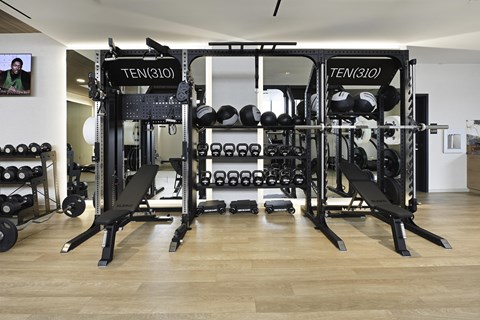 A gym with a TEN(310) weight rack and a bench.