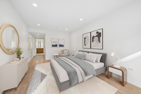 A bedroom with a large bed and a mirror on the wall.