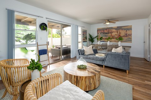 A living room with a grey couch, a wooden table, and a painting on the wall.