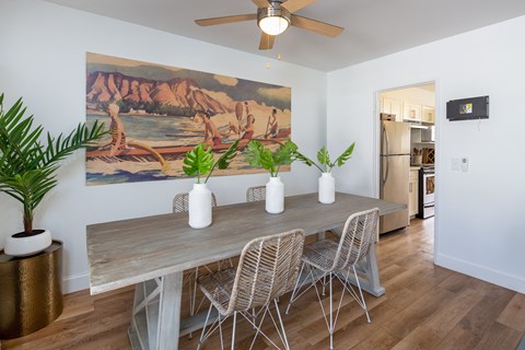A dining room with a wooden table and chairs.