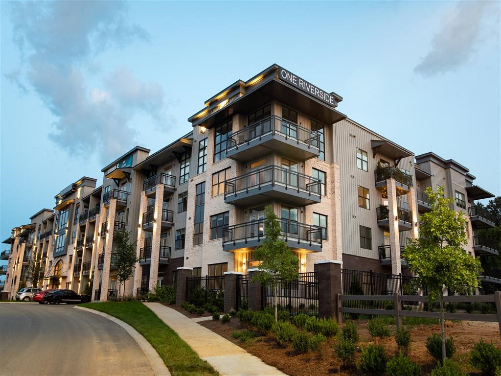an apartment building with a sidewalk in front of it
