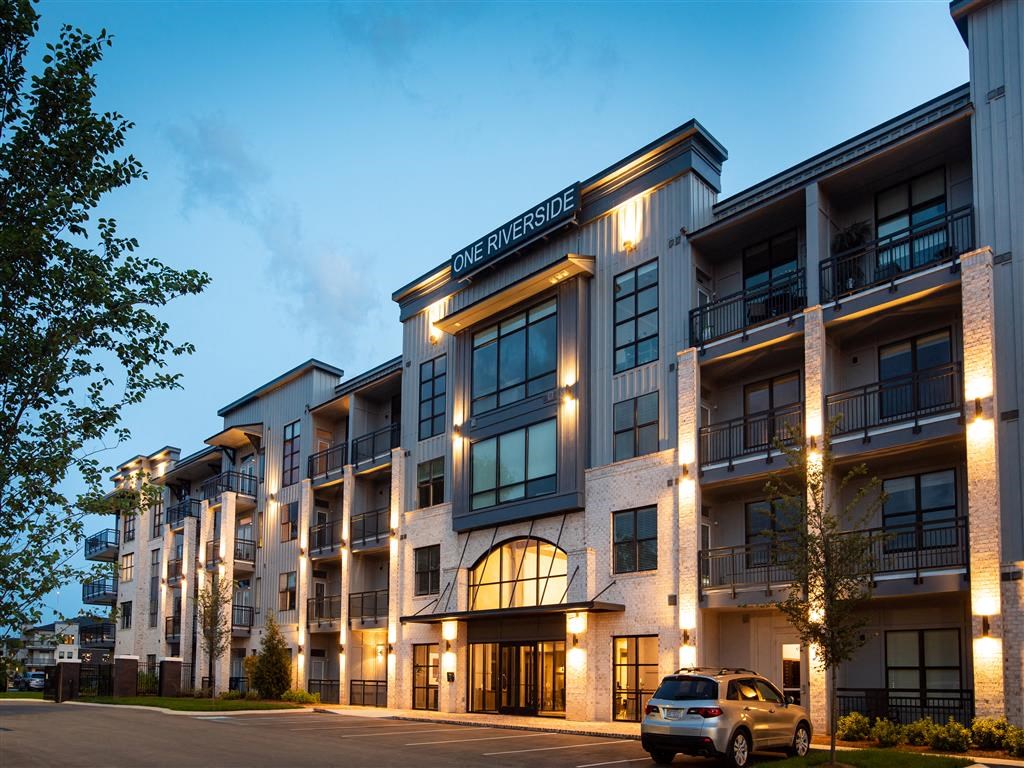 a car is parked in front of an apartment building at night