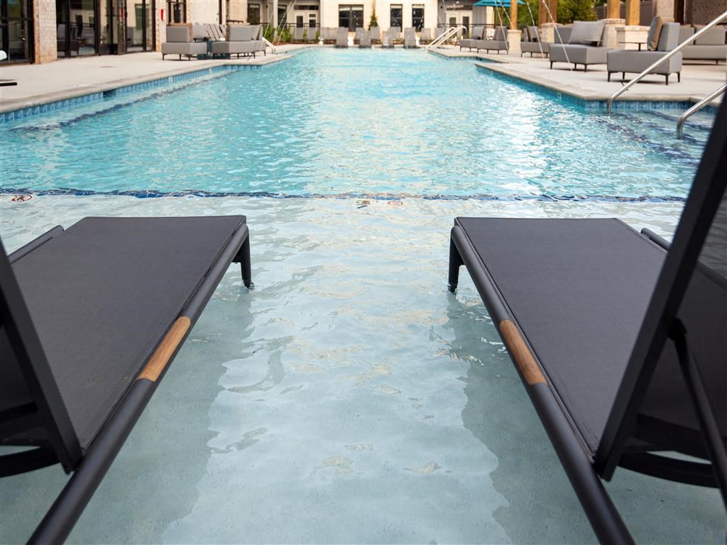 a swimming pool with two black benches in the water