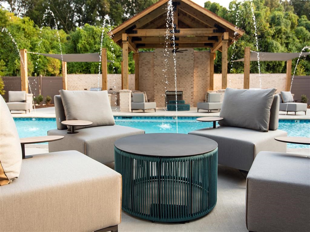 a patio with chairs and a pool and a gazebo