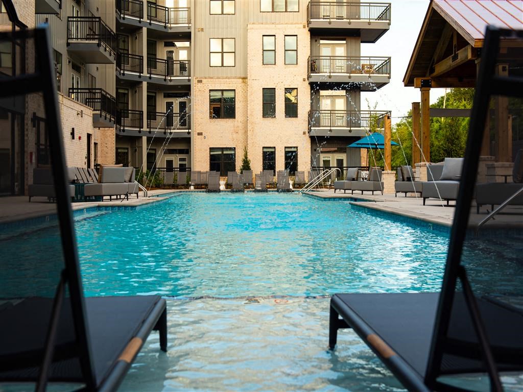 a large swimming pool in front of an apartment building