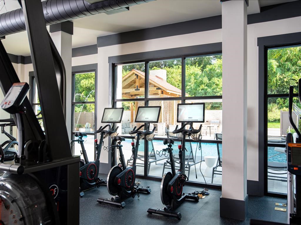 a gym with cardio machines and a view of a swimming pool