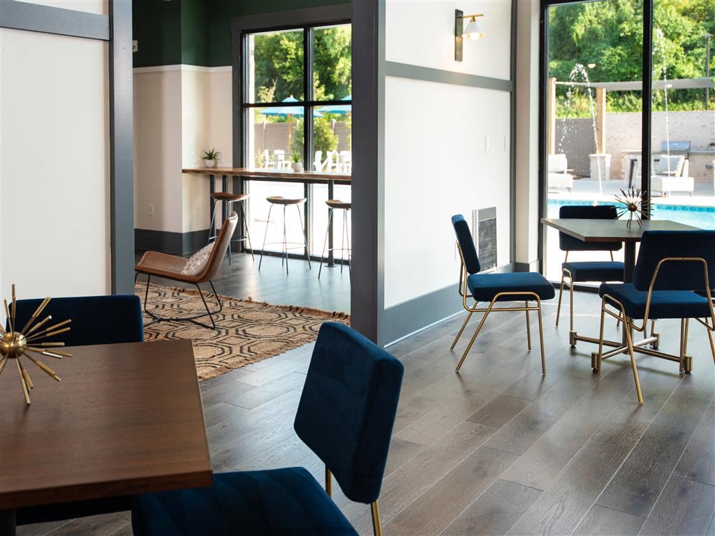 a communal area with tables and chairs and a swimming pool