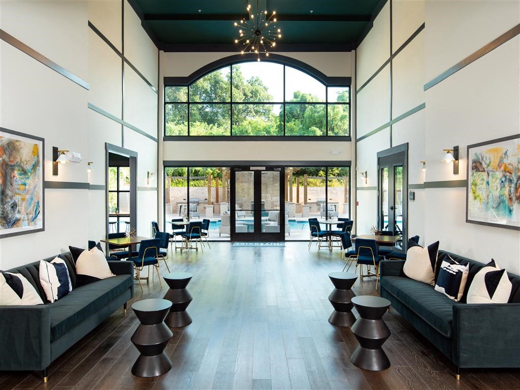 a large lobby with couches and tables and a large window