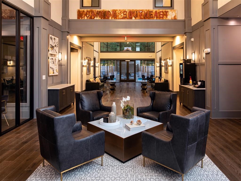 a lobby of a hotel with chairs and a table