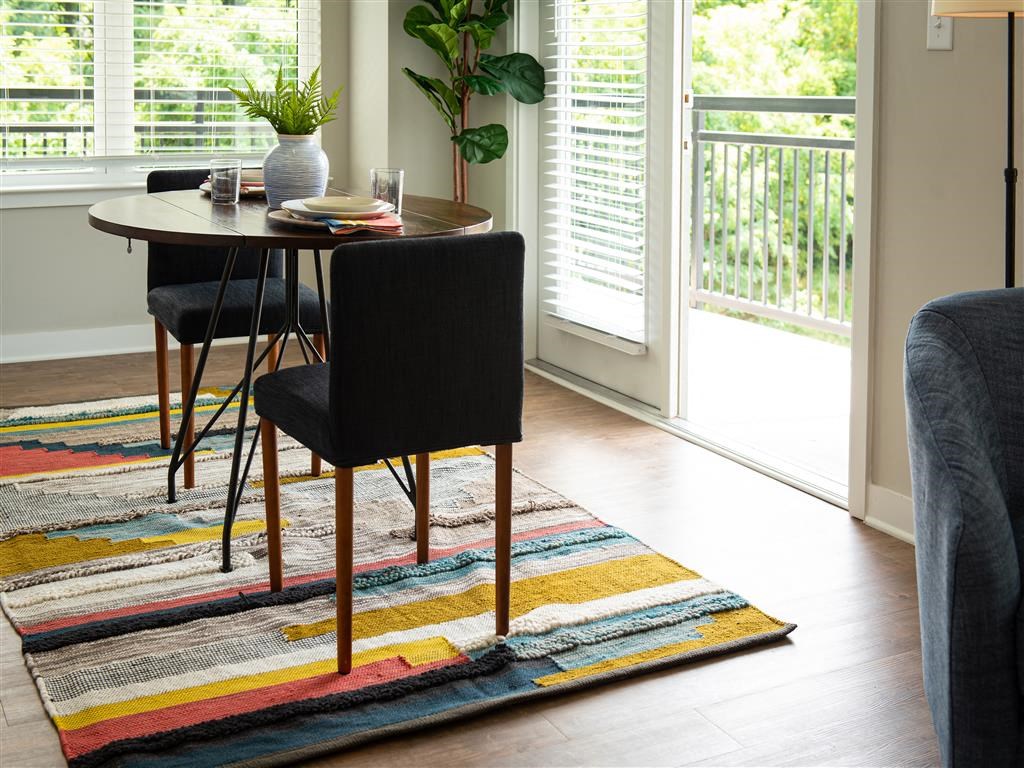 a dining room with a table and chairs on a rug