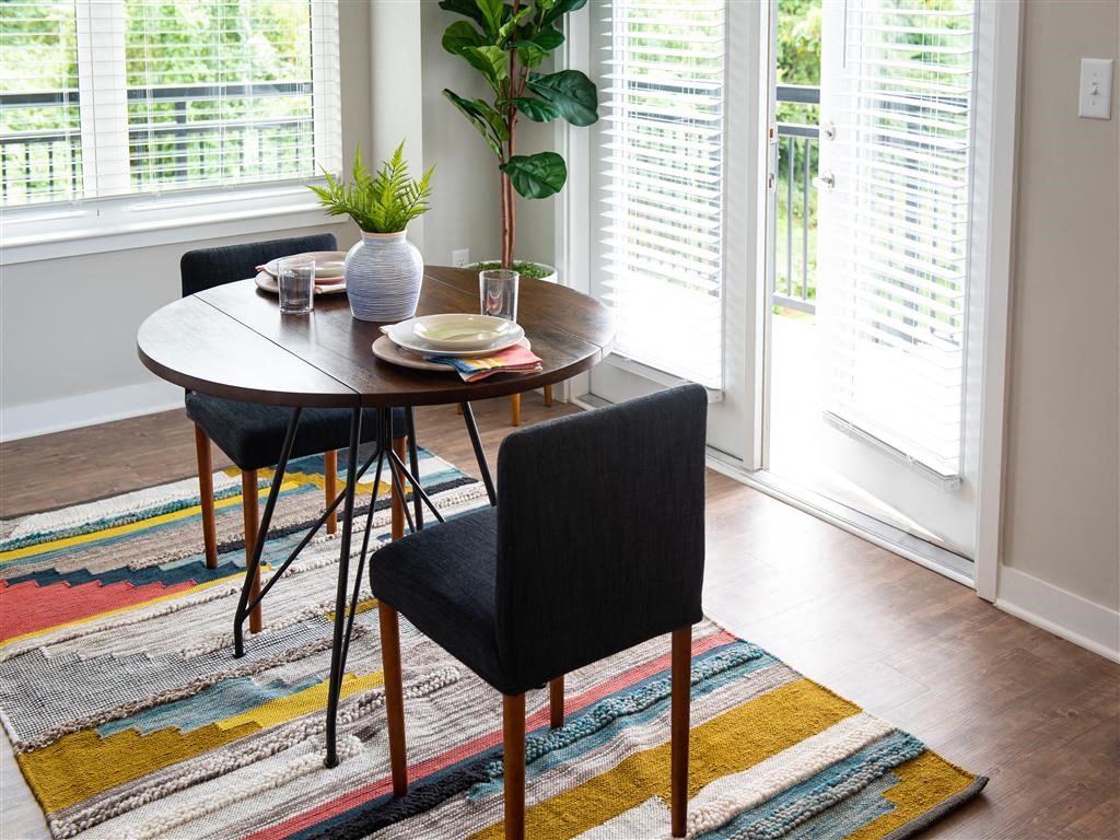 a dining room with a table and chairs and a rug