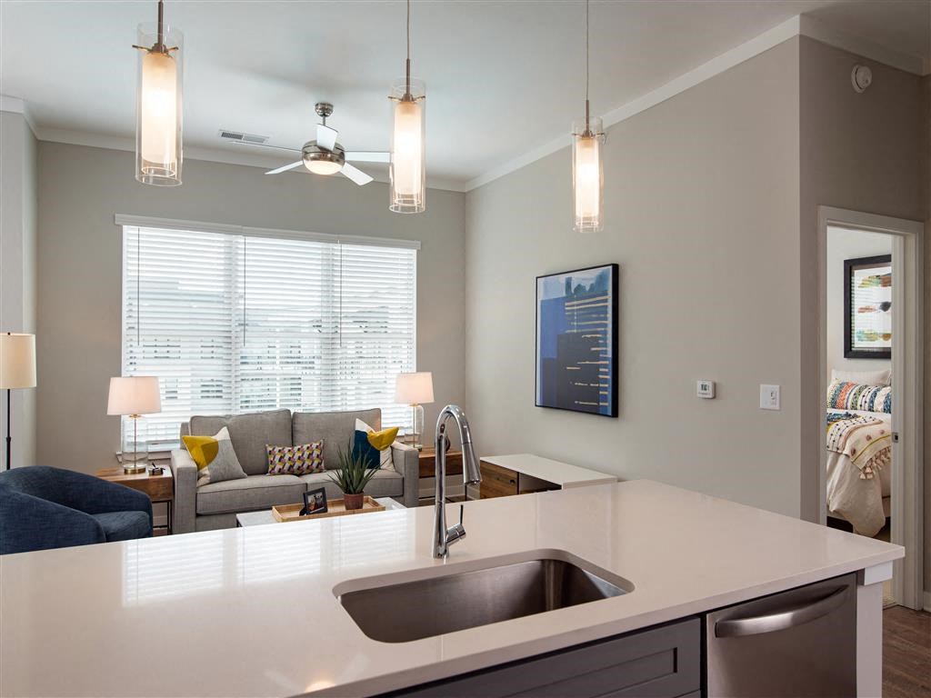 a kitchen with a sink and a view of a living room