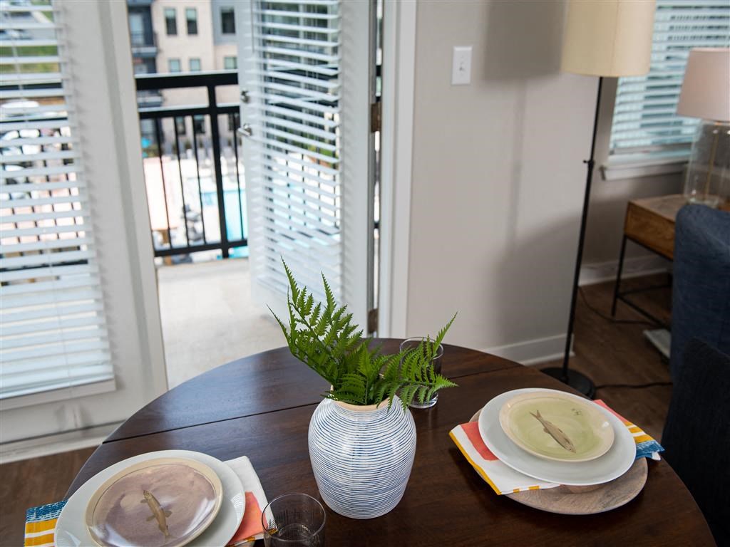 a dining room table with plates and a vase with a plant