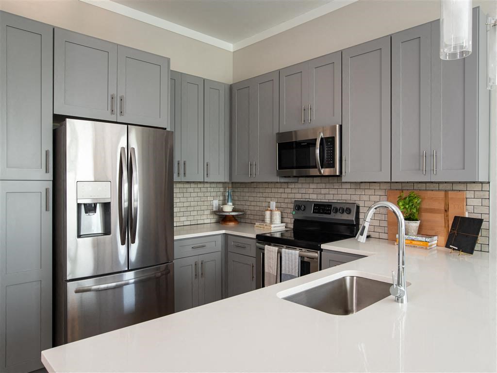 a kitchen with stainless steel appliances and white counter tops