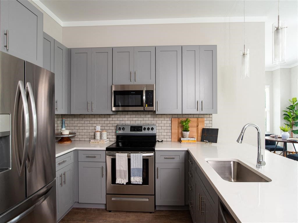 a kitchen with stainless steel appliances and gray cabinets