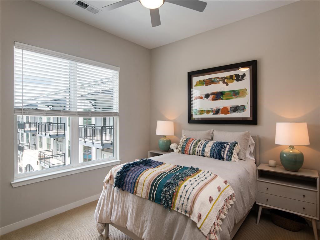a bedroom with a large window and a bed