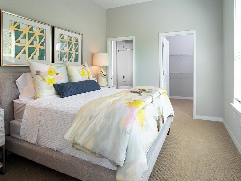 a bedroom with a bed and a door to a closet