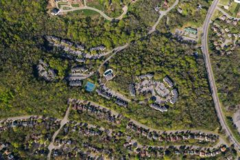 A satellite image of a residential area with houses surrounded by trees.