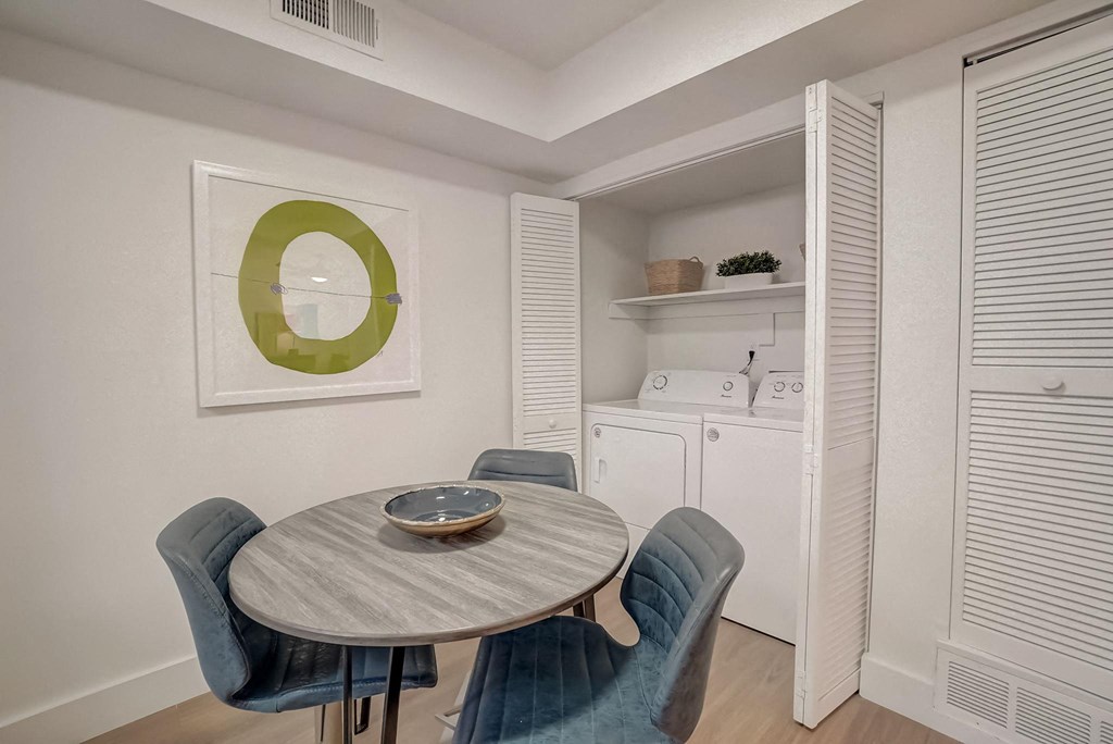 A dining room with a round table and chairs.