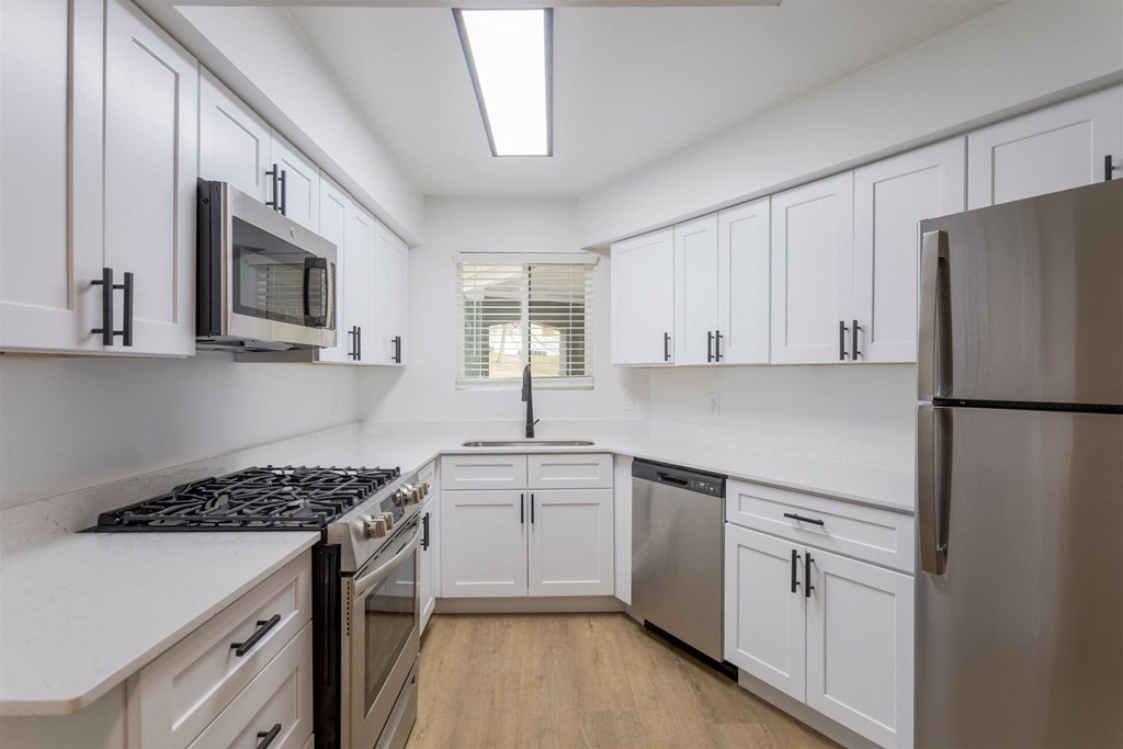 A kitchen with white cabinets and a black stove top oven.