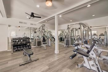 A spacious gym with a variety of equipment including treadmills, weights, and exercise machines.