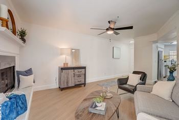 A living room with a fireplace, a chair, a couch, and a coffee table.
