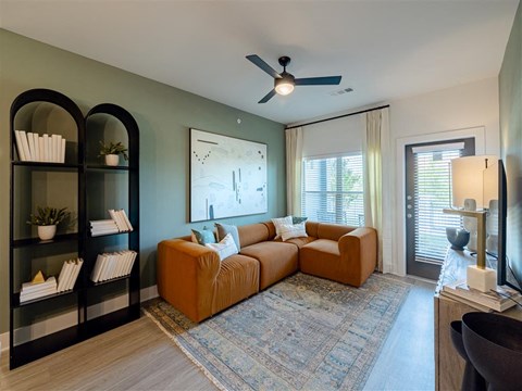 a living room with a couch and a ceiling fan