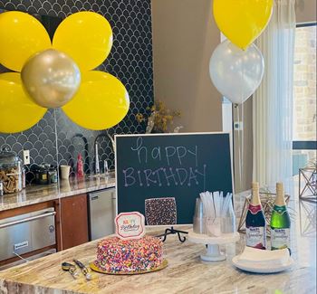 a birthday party with a cake and balloons