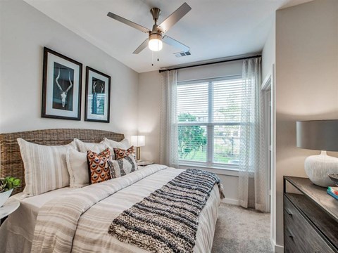 A bedroom with a large bed and a ceiling fan.