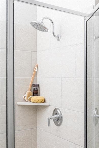 a bathroom with a shower and a shelf in it