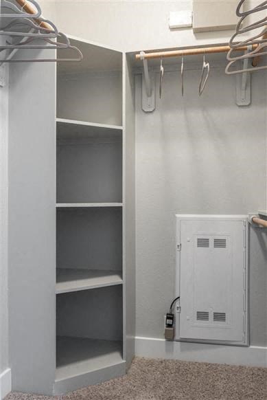 a white closet with shelves and a white door