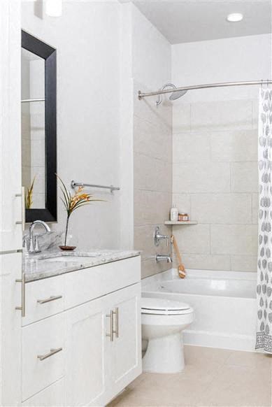 a white bathroom with a white toilet and a shower