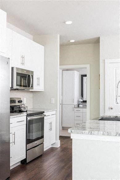 a kitchen with stainless steel appliances and white cabinets