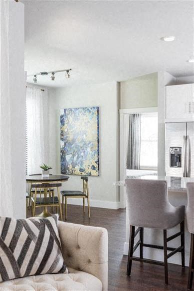 a living room and kitchen with a couch and chairs