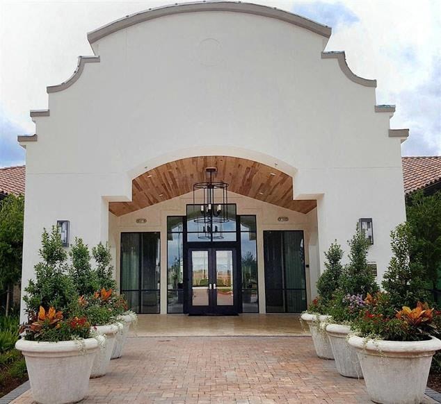 the front of a building with large pots of plants