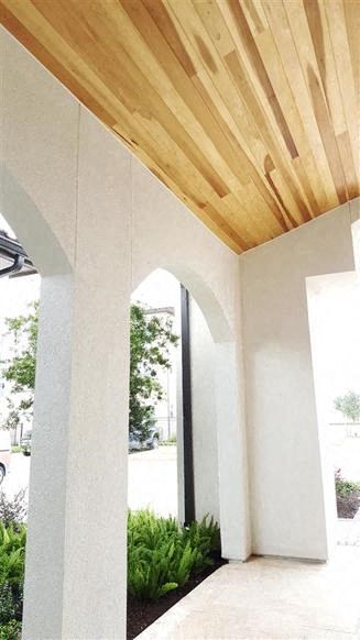 a porch with a wooden ceiling and some plants