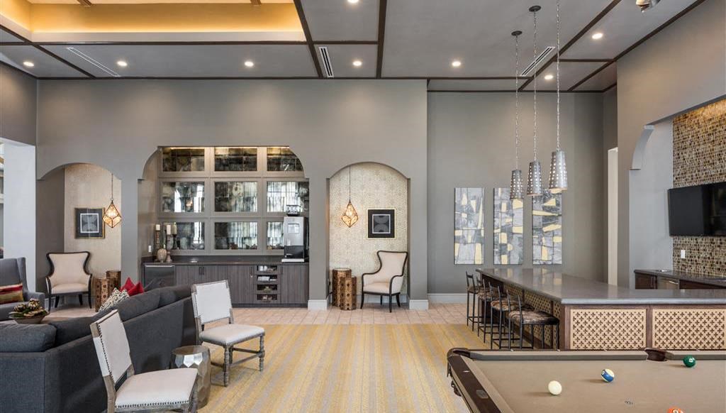 a living room with a pool table and a bar