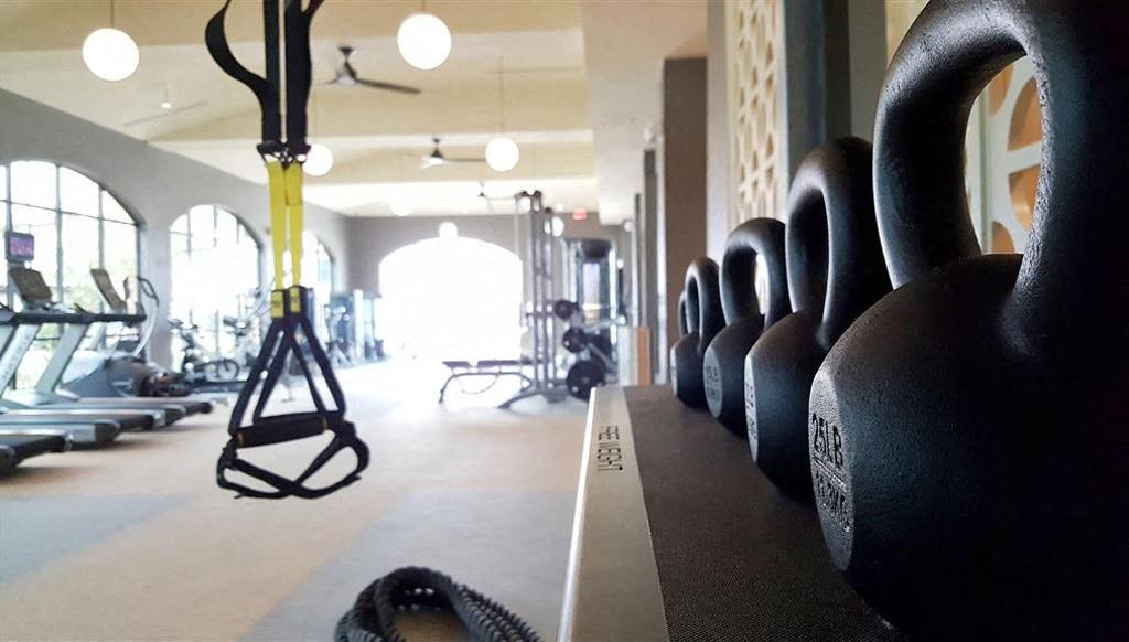 a gym with weights and a row of chairs