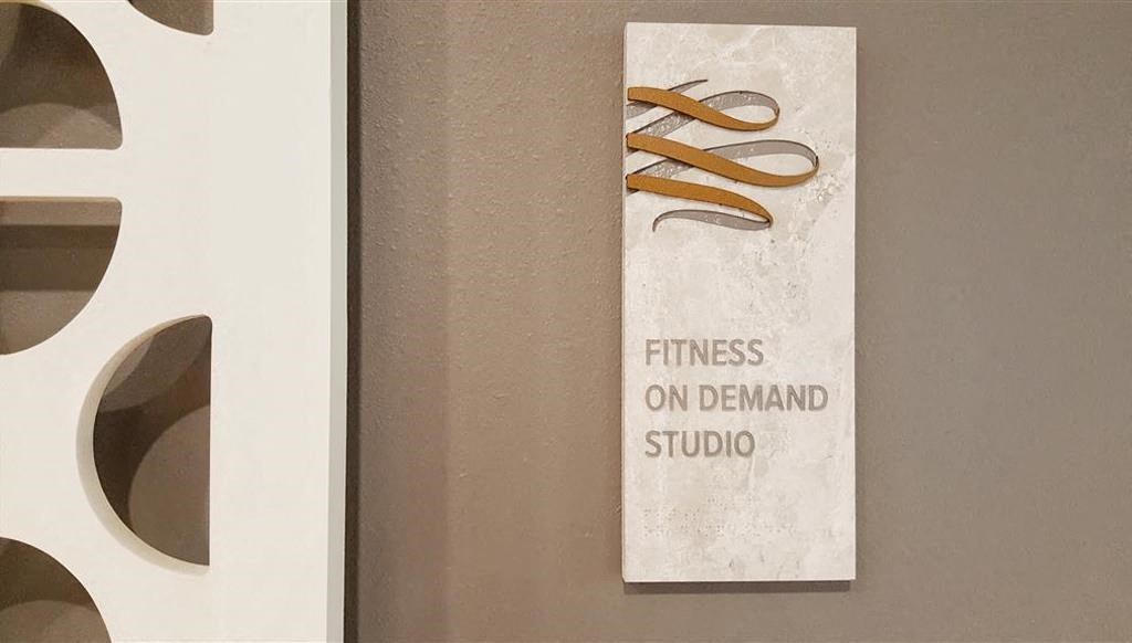 a sign for a fitness on demand studio on a wall