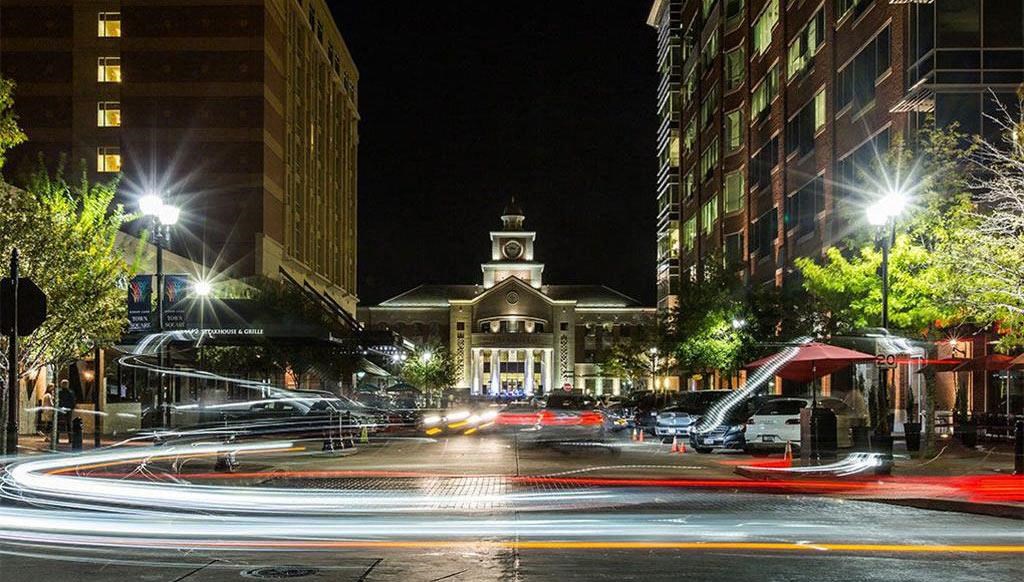 a city street at night with a clock tower