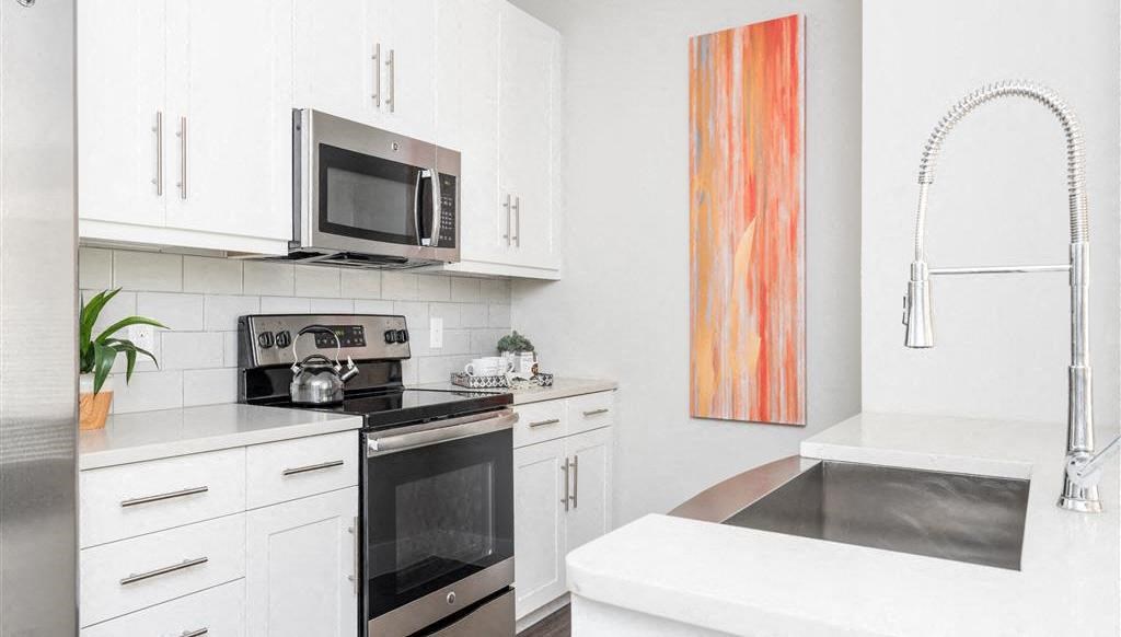 a white kitchen with a stove and a microwave