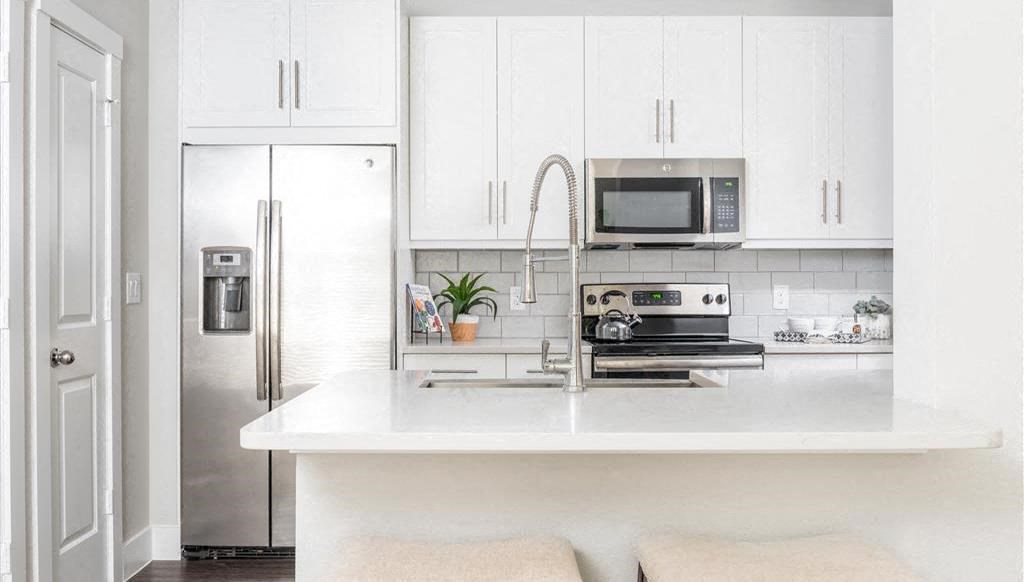 a white kitchen with a sink and a microwave