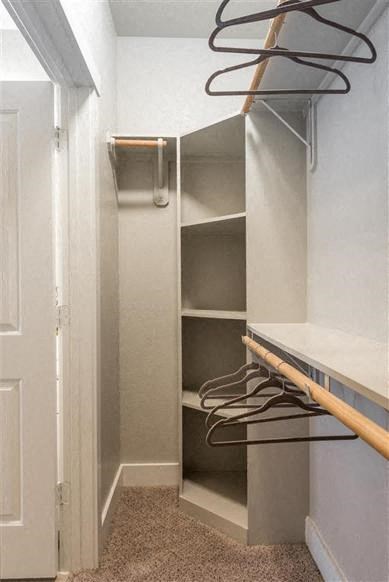 a walk in closet with shelves and hangers