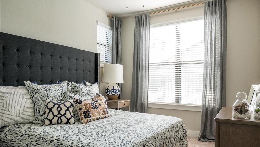 a bedroom with a bed and two windows