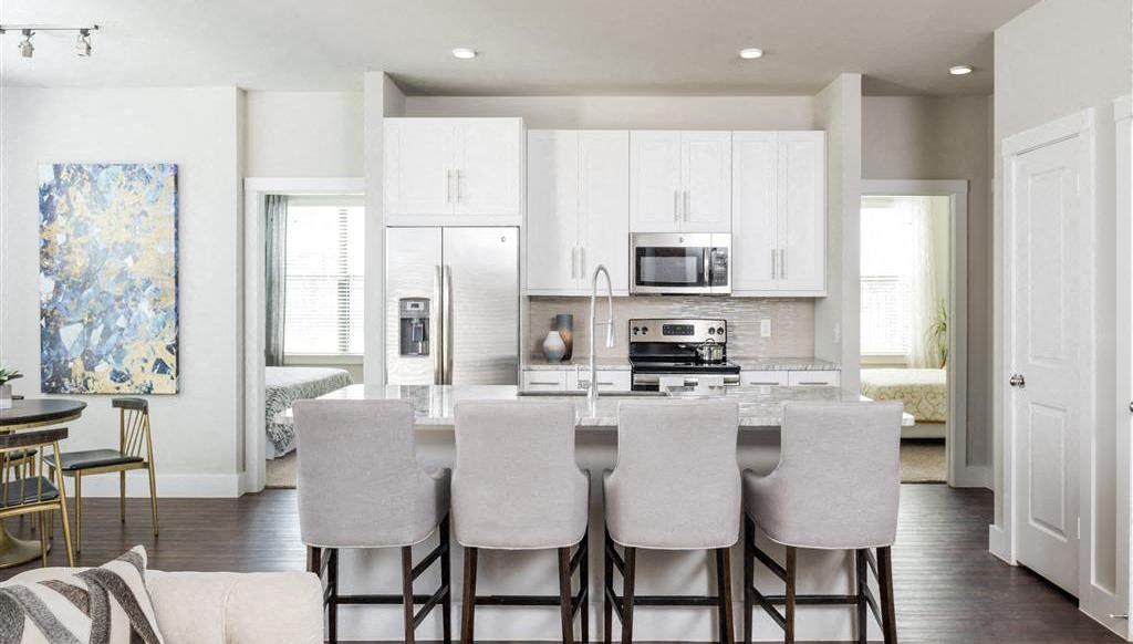a kitchen with a marble counter top and white cabinets