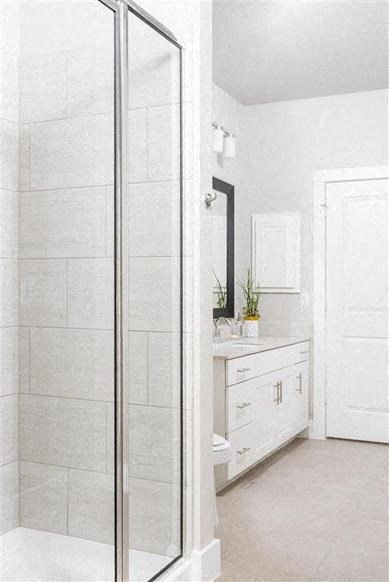 a white bathroom with a shower and a sink