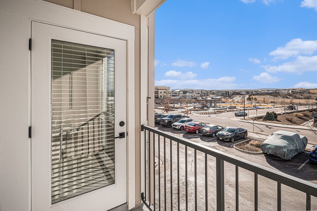 A view from a balcony looking out at a parking lot.