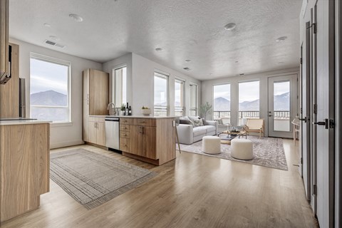 A modern kitchen with wooden cabinets and a large window overlooking the mountains.
