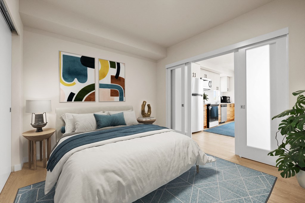 a bedroom with white walls and a large bed with blue and white bedding at Ion Town Center, Shoreline, WA