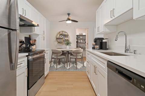 A kitchen with a table and chairs in the middle.